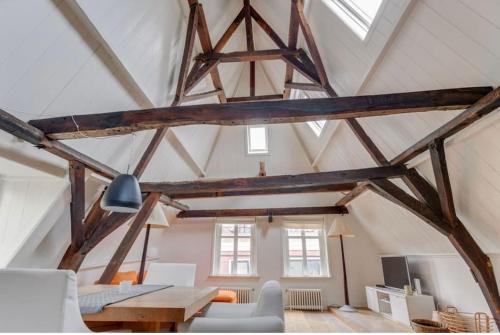 a loft with wooden beams and a living room at Hoogwaardig afgewerkt loft in oude stadscentrum in Alkmaar