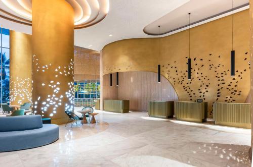 a lobby of a hotel with gold walls at Hilton Santa Marta in Santa Marta