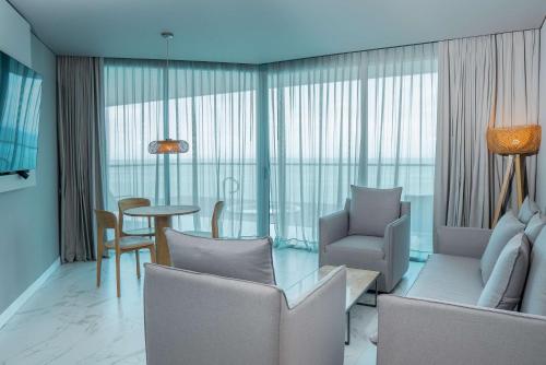 a living room with chairs and a table and a dining room at Hilton Santa Marta in Santa Marta