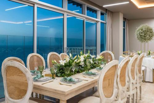 a dining room with a table and chairs and windows at Hilton Santa Marta in Santa Marta