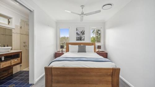a bedroom with a bed and a sink at Mango Cottage 8, Pool, Sleeps 8, Aircon in Sawtell