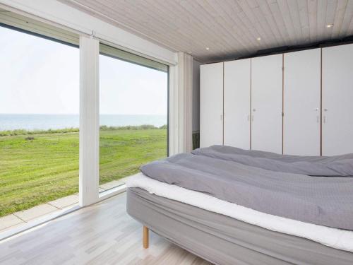 una camera da letto con un letto grande e una grande finestra di Seaside Panorama Retreat - By Traum Ferienwohnungen a Odder