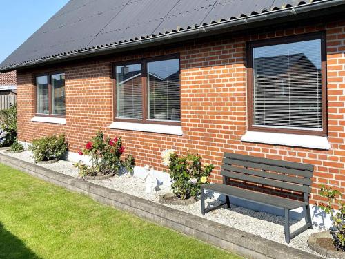 a bench sitting in front of a brick house at 10 person holiday home in Ålbæk-By Traum in Ålbæk