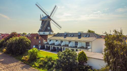 un mulino a vento in cima a un edificio con una casa di Küstenrose a Carolinensiel