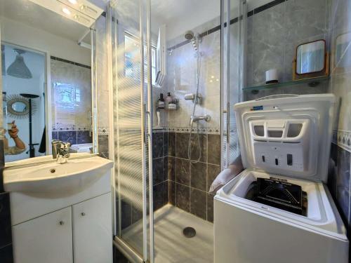 une salle de bain avec une douche à l'italienne à côté d'un lavabo dans l'établissement T2 Climatisé rénové avec Parking et Piscine pour 4 près de la mer - FR-1-607-205, au Cap d'Agde