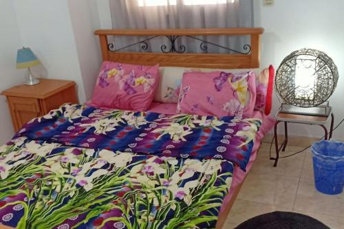 a bedroom with a bed with a colorful comforter at Universal family apartment in Cairo