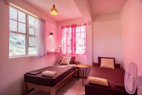 une chambre avec deux lits, une table et des fenêtres dans l'établissement Rosehill Heights Modern 4 bedroom vacation rental, à Soufrière