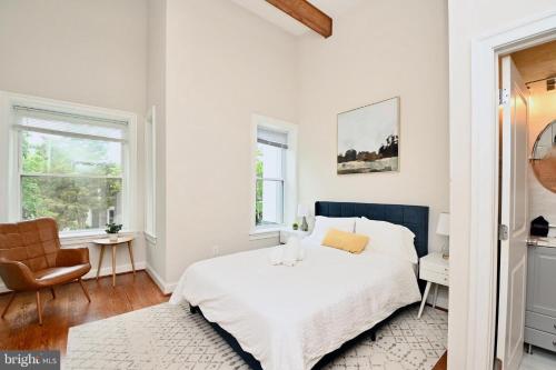 a white bedroom with a bed and a chair at Elegant 5BR home near Capitol Hill! Free Parking! in Washington, D.C.