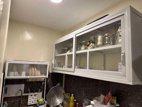 a kitchen with white cabinets with pots and pans at Sunny Villa in Angeles