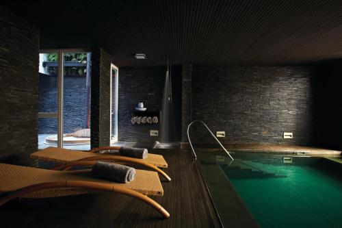 a room with a swimming pool with chairs and a swimming pool at Palacio Astoreca in Valparaíso