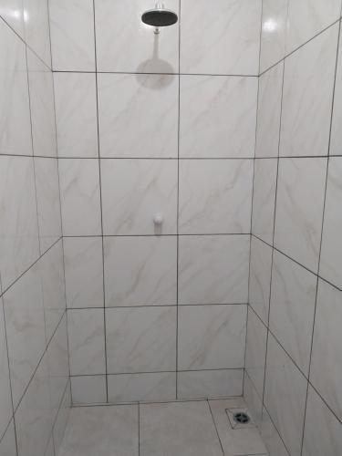 a shower with white tiled walls and a light at APT Raphis C in Santarém
