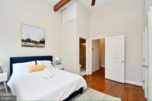 a white bedroom with a large bed with a blue headboard at Elegant 5BR home near Capitol Hill! Free Parking! in Washington, D.C.