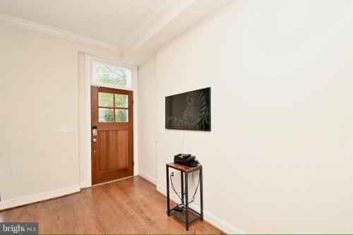 an empty room with a door and a television on a wall at Elegant 5BR home near Capitol Hill! Free Parking! in Washington, D.C.
