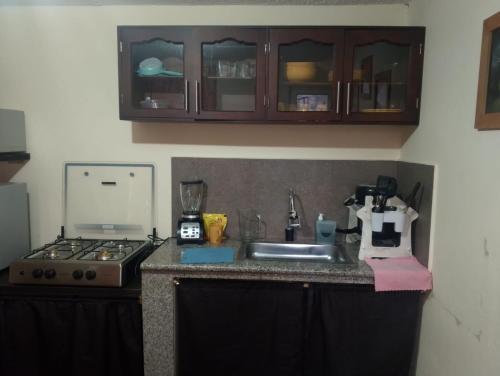 a kitchen counter with a sink and a stove at Crocro house in Baños