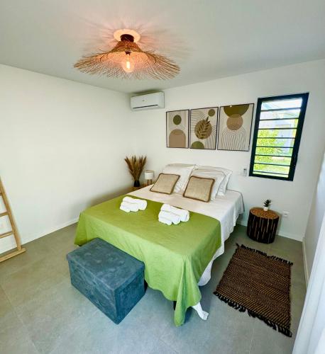 a bedroom with a bed and a ceiling fan at Les Jardins d'Oklm in Orient Bay