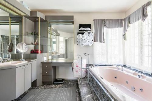 a bathroom with a tub and a sink and a mirror at La maison de Gabriel in Quebec City