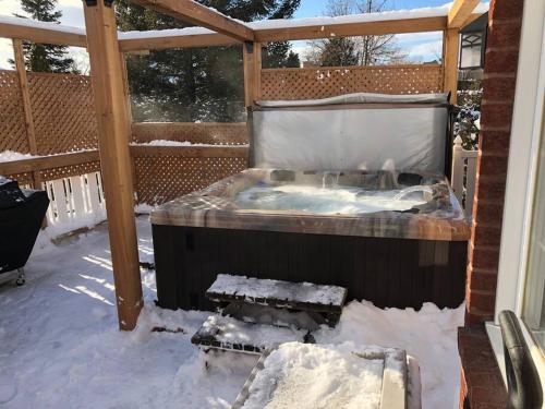 a hot tub on a deck in the snow at La maison de Gabriel in Quebec City
