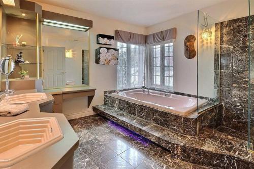 a large bathroom with a tub and a sink at La maison de Gabriel in Quebec City