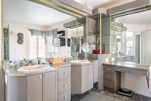 a bathroom with two sinks and two mirrors at La maison de Gabriel in Quebec City