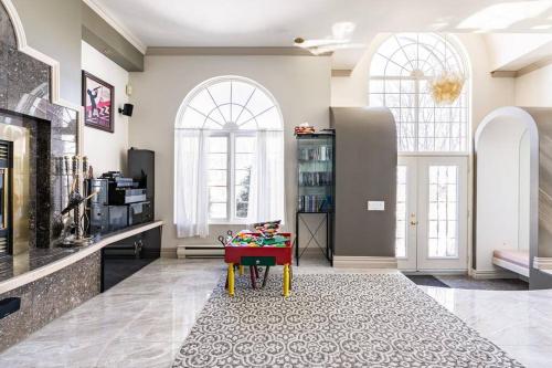 a living room with a table and two windows at La maison de Gabriel in Quebec City