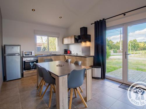 une cuisine et une salle à manger avec une table et des chaises dans l'établissement Gîte moderne et confort, proche Puy du Fou, Nantes, Cholet, terrasse, pêche à l'étang privé - FR-1-622-42, à La Renaudière