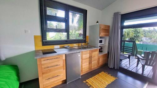 a kitchen with a sink and a large window at TAHITI - Mango Lodge Moana in Papara