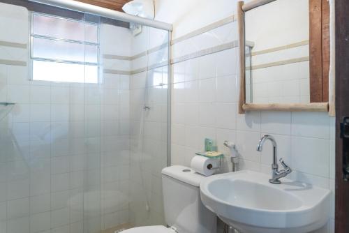 a bathroom with a toilet and a sink and a mirror at Pousada Trilha do Mar in Praia do Frances
