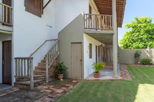 a courtyard of a house with stairs and plants at Pousada Trilha do Mar in Praia do Frances
