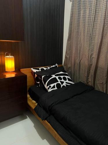 a bedroom with two beds with black and white pillows at Trina's Suites in Manila
