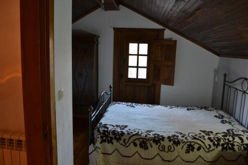 a bedroom with a bed and a window at Casa de Onor in Rio de Onor
