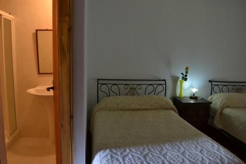 a small bedroom with a bed and a bathroom at Casa de Onor in Rio de Onor