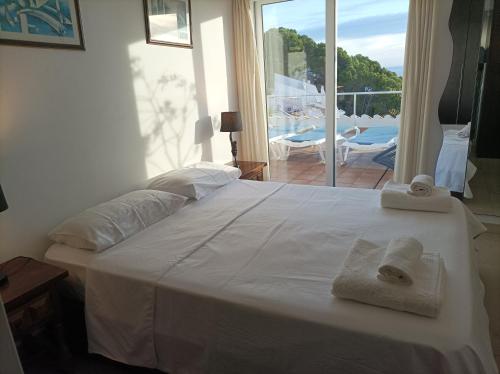 ベグールにある"Terrasse de la Mer 8" Résidence"Sol y Mar" AC-Wifi-BBQ-Piscine-Pkgのタオルが敷かれた大きな白いベッドのある寝室