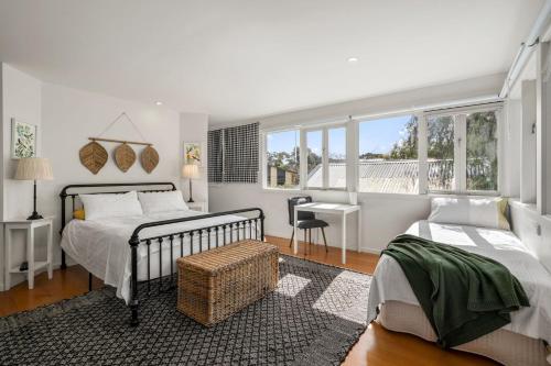 a bedroom with two beds and a desk in it at Seaside Sanctuary in Saint Leonards