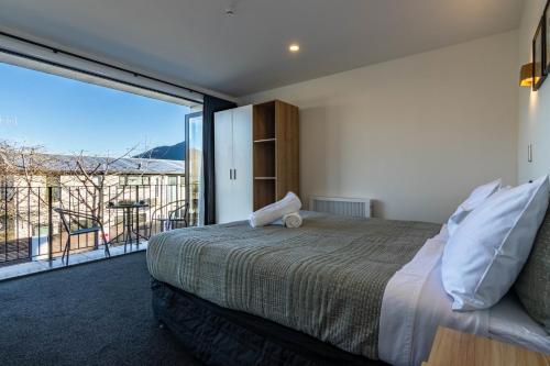 クイーンズタウンにあるSpacious Central Executive 4 Bedroom Apartmentの大きなベッドと大きな窓のある寝室