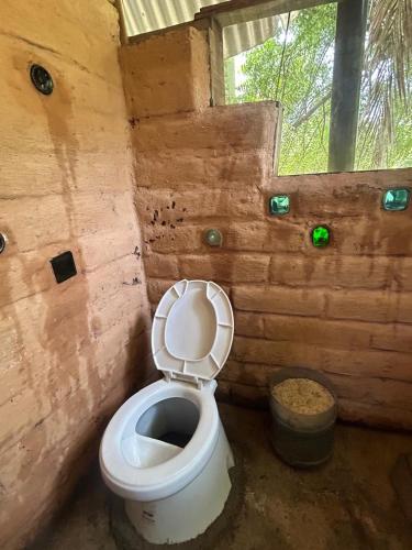 a bathroom with a toilet in a wooden room at Casa de las brujas hostal in Zipolite