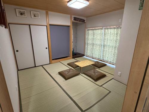 an empty room with a table and chairs in it at 和良和楽の宿 in Hikone
