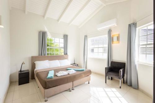 a bedroom with a bed and a chair in it at Artiko Luxury Suites - Jan Thiel in Jan Thiel