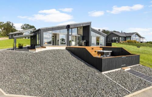 オーベンローにあるAwesome Home In Aabenraaの砂利の上に黒いファサードを持つ現代的な家