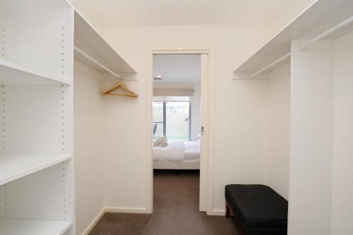 a room with white walls and a bedroom with a bed at Ground Level 1-Bed: Courtyard & Alfresco Dining in Weston Creek