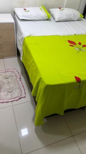 a bed with a green blanket on it in a room at Fit room in Santarém