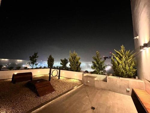 a patio with a bench and a view of the ocean at night at Lovely and Peaceful Home in Guatemala