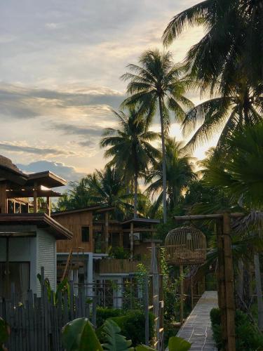 a resort with palm trees in the background at บ้านพราวพร้าว Baan Proud Proud in Khanom