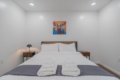 a bedroom with a large white bed with two chairs at The Pet Friendly Executive Northernwind Suite 1.0 in Fairbanks