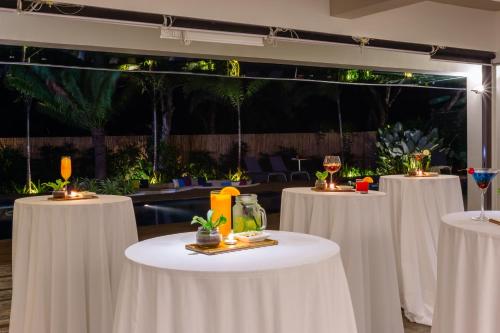 a row of white tables with wine glasses on them at Canvas Boutique Hotel in Puerto Princesa City