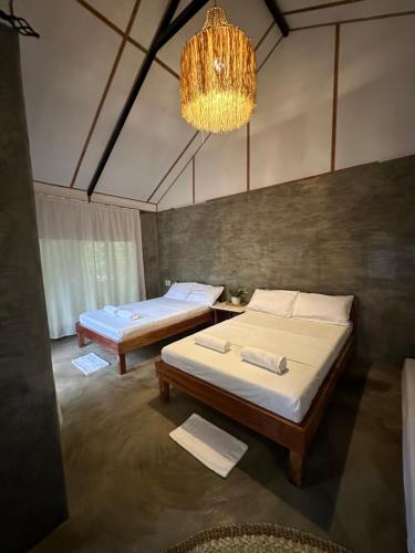 a bedroom with two beds and a chandelier at Bohol Island Homestay in Dauis