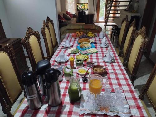a table with food and drinks on a checkered table cloth at Pousada Bonamigos in Santa Teresa