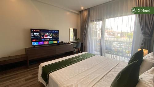a hotel room with a bed and a flat screen tv at X Hotel Thái Nguyên in Thái Nguyên