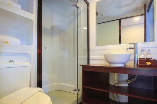 y baño con lavabo y ducha acristalada. en Mars City Hotel, en Denpasar