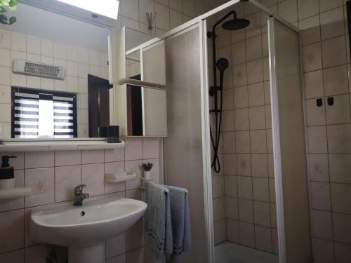 a bathroom with a sink and a shower at Kuća za odmor "Villa Merkur" - Orahovica in Orahovica
