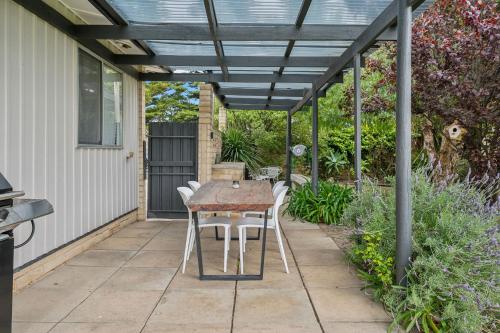 a patio with a table and chairs under a pergola at Percys Place- Waterfront pet and family friendly in Goolwa